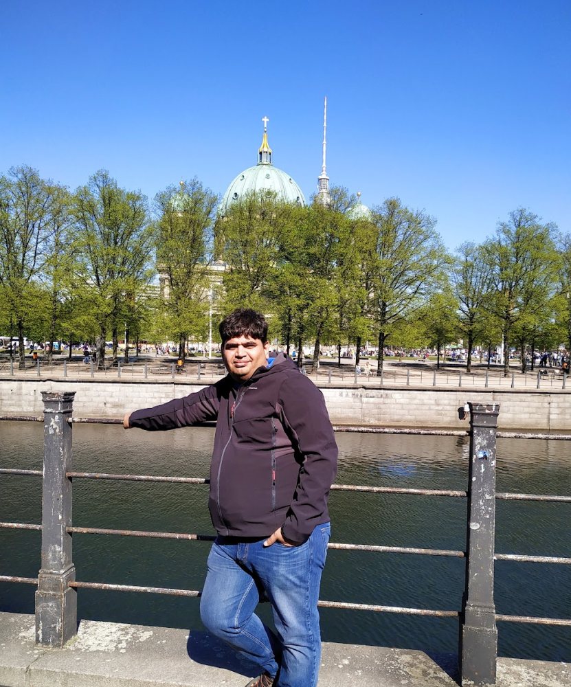 Vishwa Ranjan on a bridge over the Spree with Berlin Cathedral behind