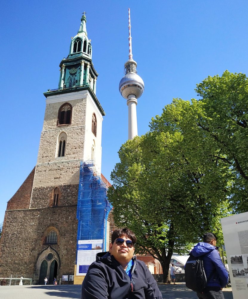 Vishwa Ranjan with St Mary's Church and the Fernsehturm television tower behind