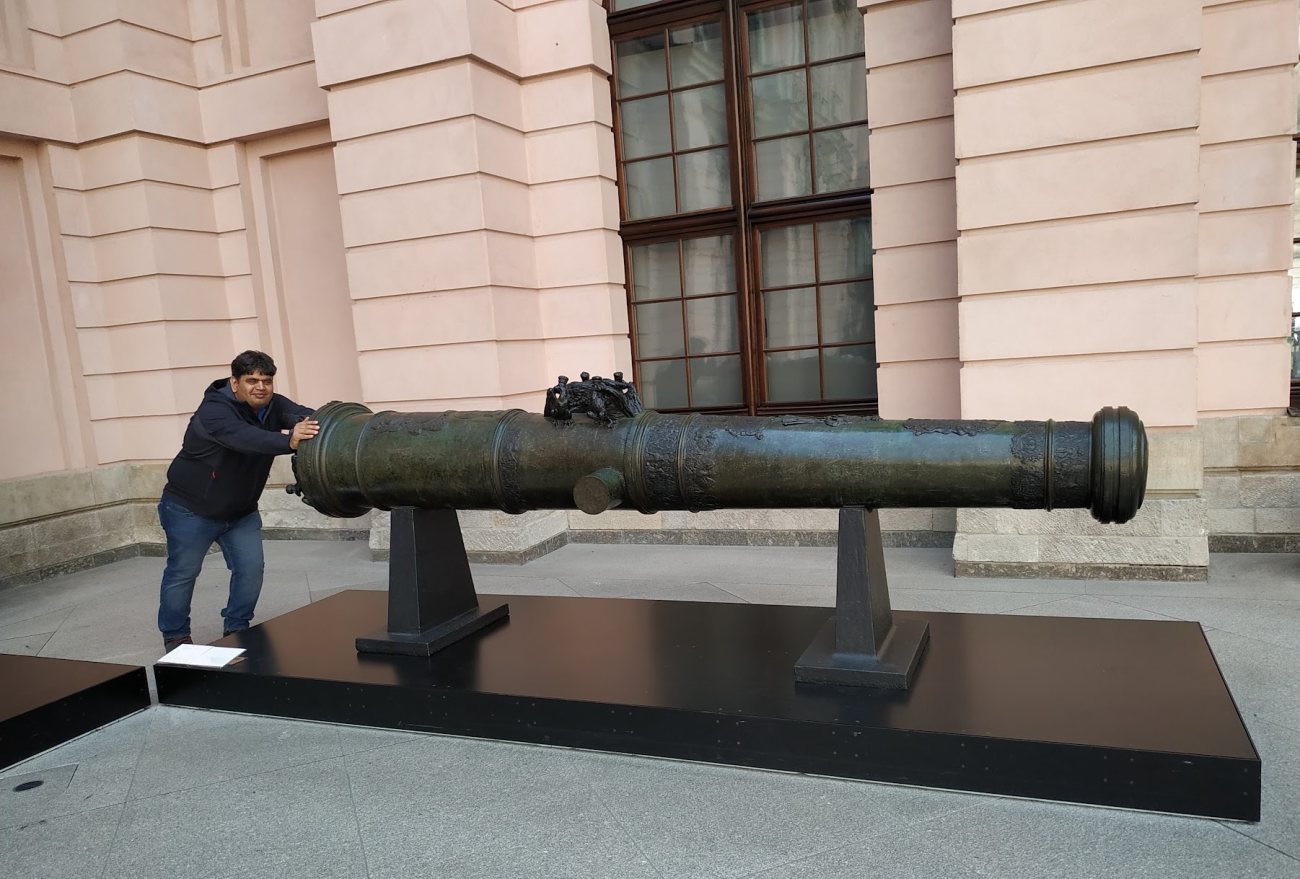 Vishwa Ranjan pretending to push a historic bronze cannon outside the Zeughaus